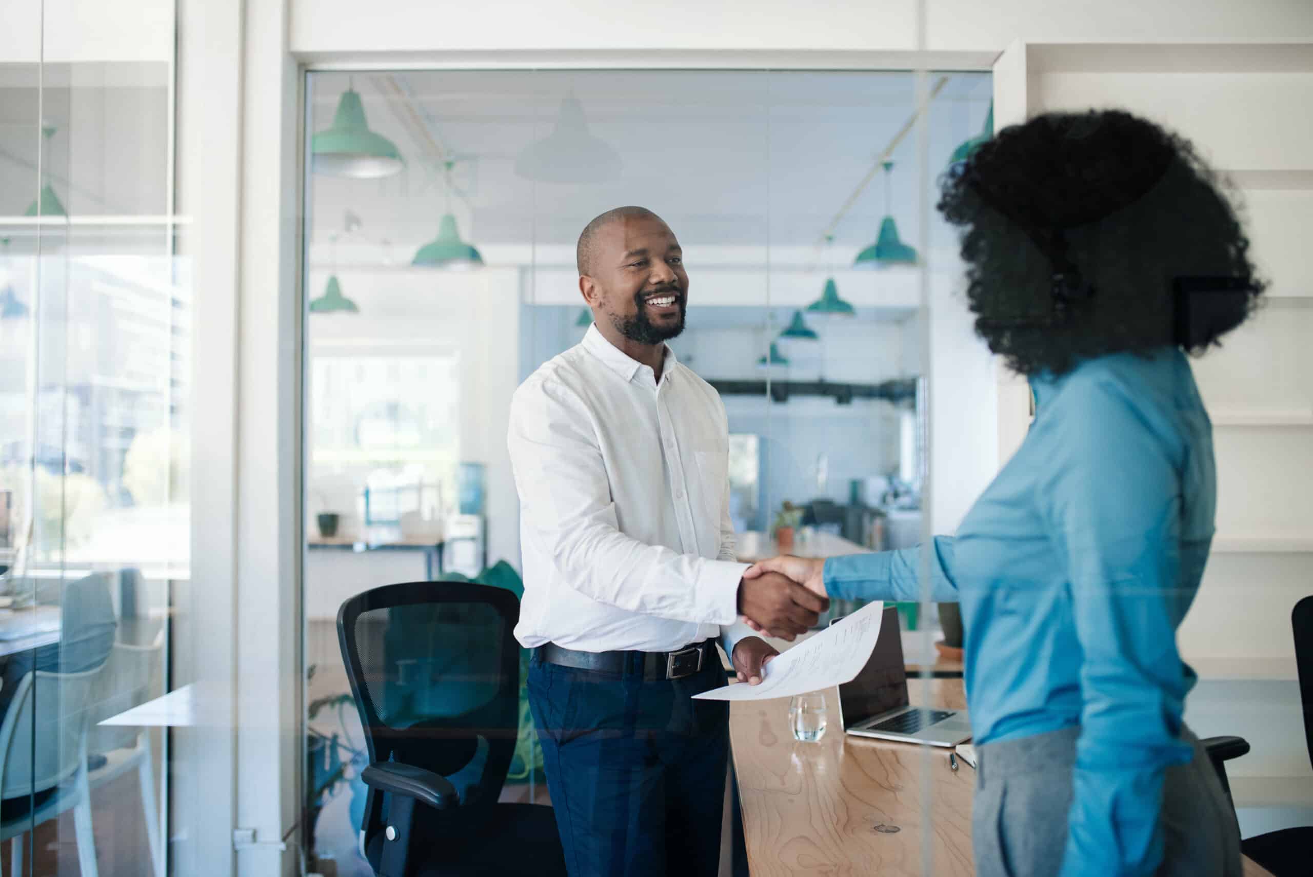 Smiling HR manager meeting with a new hire employee.