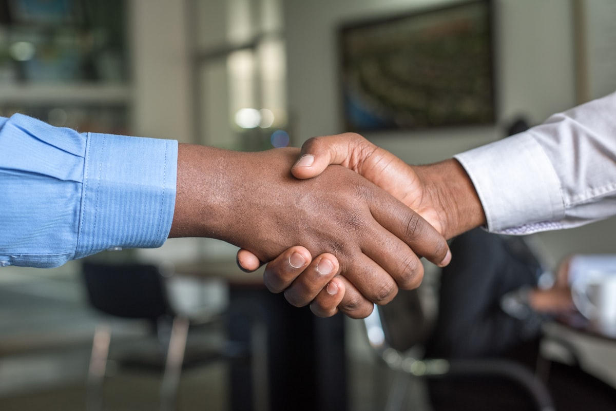 Business partnership handshake representing UKG Ready partner vs direct implementation decision